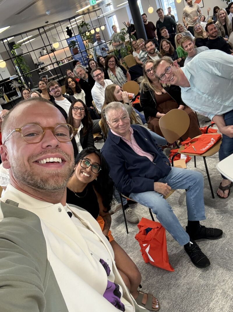 Smiling audience posing for a group selfie at an office event.
